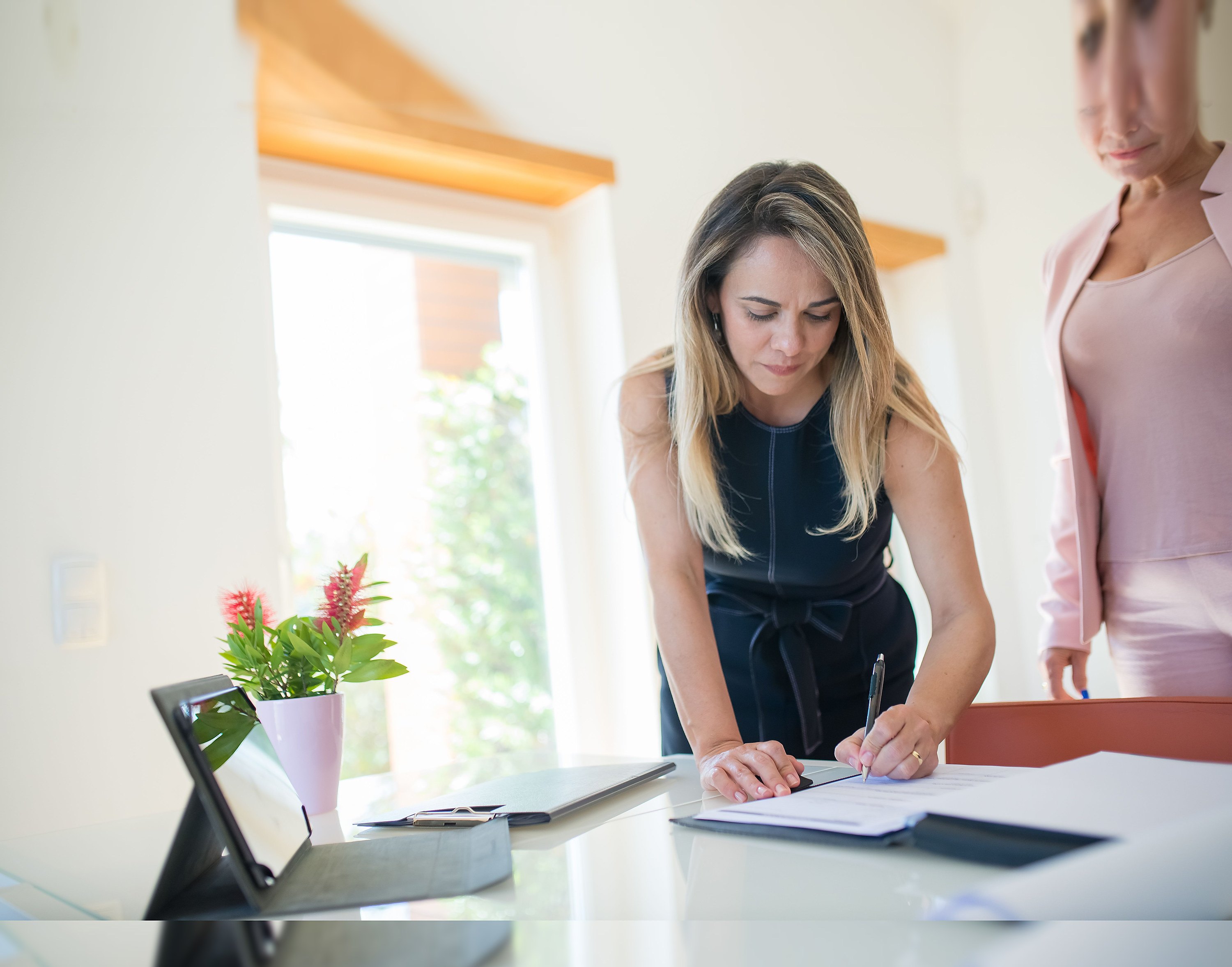A woman signing a document representing operating teams