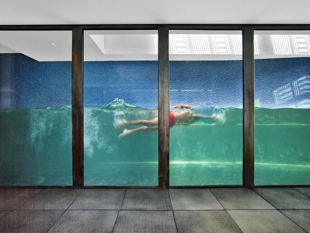 Swimmer seen through the glass wall of the lap pool at 109 Waverly Place