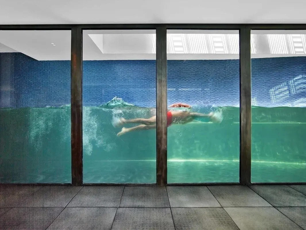 Swimmer seen through the glass wall of the lap pool at 109 Waverly Place